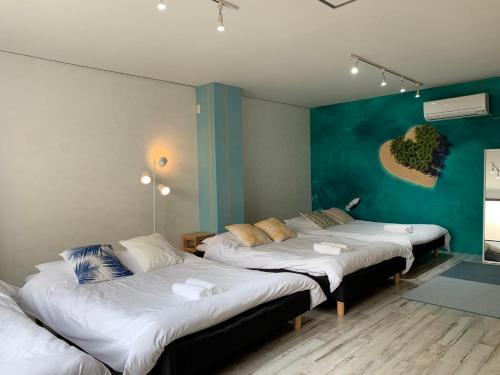 - 2 lits dans une chambre dotée d'un mur vert dans l'établissement Ex2 House Imamiya 202, à Osaka