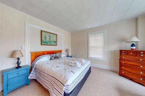 a bedroom with a large bed and a blue dresser at Lisa Jean's Lookout in Boothbay Harbor