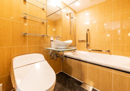 a bathroom with a toilet and a sink and a tub at APA Hotel Akihabara Ekikita in Tokyo