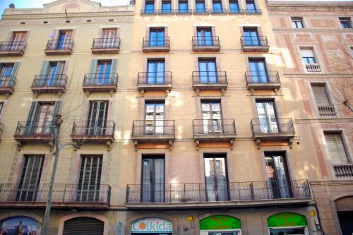 un edificio alto con balcones a un lado. en Hostal Colkida en Barcelona