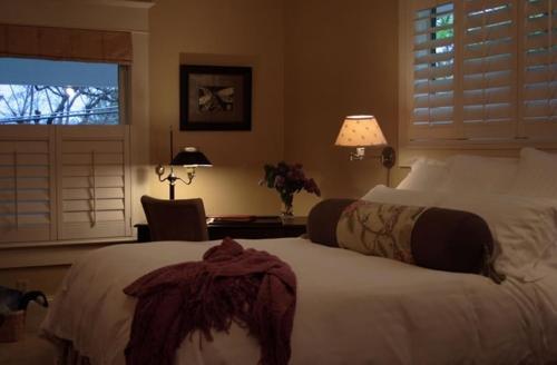 a bedroom with two beds and a desk and a window at The White House Bed and Breakfast in Medford