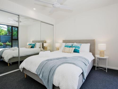 a bedroom with two beds and a mirror at Husky Sands I Pet Friendly I 5 Mins Walk to Beach in Huskisson