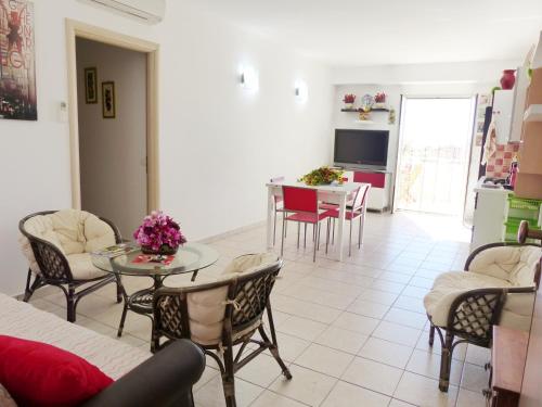een woonkamer met een tafel en stoelen bij siciliacasevacanze - Ulivi in Marina di Ragusa