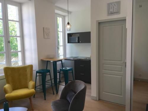 sala de estar con mesa y sillas y cocina en L ORATOIRE 1, en La Rochelle