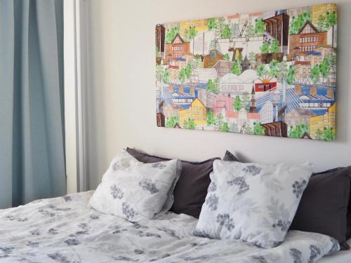 a bed with two pillows and a painting on the wall at Feels like Arctic City in Rovaniemi