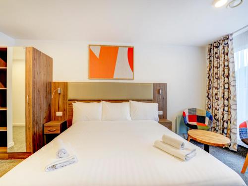 1 dormitorio con 1 cama con 2 toallas en OYO Plymouth Central Hotel en Plymouth