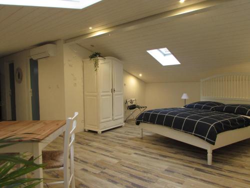 Un dormitorio con una cama y una mesa. en Le Parc - Suite climatisée, en Magrie