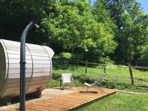 a wooden deck with a chair sitting on top of it at Yourte et son bain nordique in Fréchet-Aure