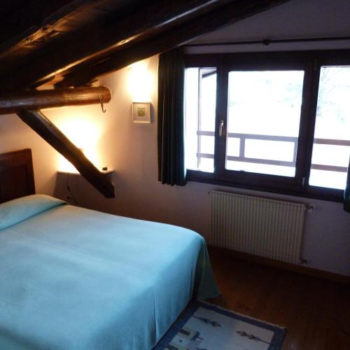 a bedroom with a bed and two large windows at Villa Margherita in Anduins