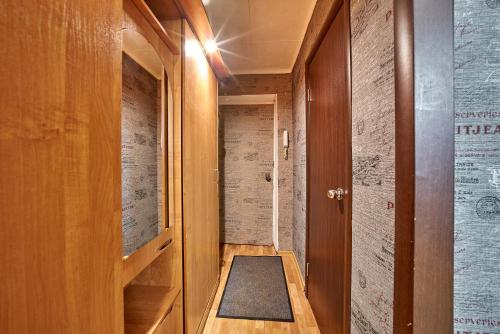 a hallway with a door and a rug on the floor at Apartment Gazeta Zvezda 75 in Perm