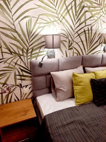 ein Schlafzimmer mit einem Sofa und einer Wand mit Blattmuster in der Unterkunft Willa Stara Chałpa in Muszyna