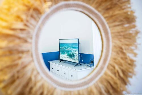 a mirror reflection of a television on a dresser at Toffee Gioberti - Seven Suites Sanremo in Sanremo