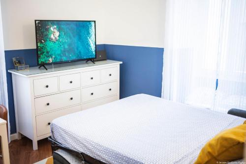 a bedroom with a bed and a tv on top of a dresser at Toffee Gioberti - Seven Suites Sanremo in Sanremo