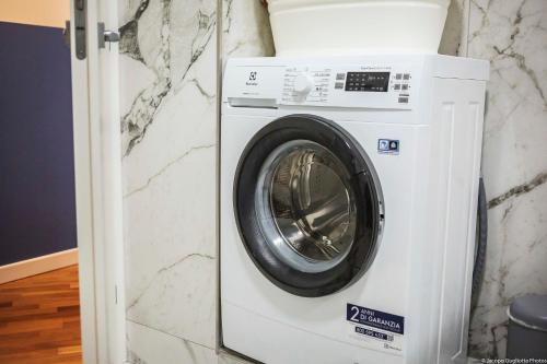 a white washing machine sitting next to a wall at Toffee Gioberti - Seven Suites Sanremo in Sanremo
