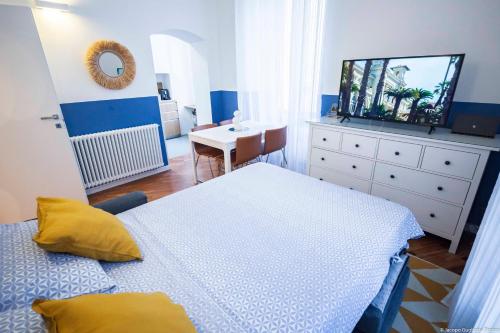 a bedroom with a bed and a table and a mirror at Toffee Gioberti - Seven Suites Sanremo in Sanremo