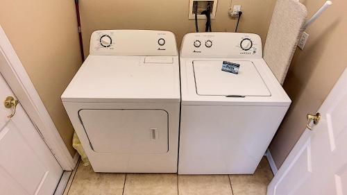 dos lavadoras sentadas una al lado de la otra en una lavandería en Safari Lodge, en Orlando