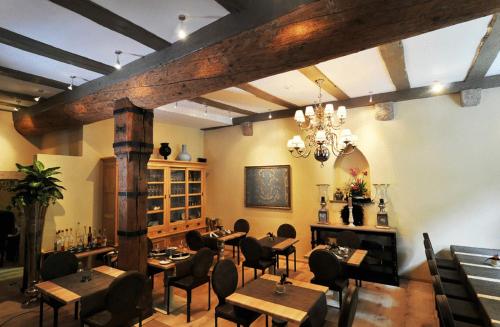 a restaurant with tables and chairs and a chandelier at Hotel Herrnschloesschen in Rothenburg ob der Tauber