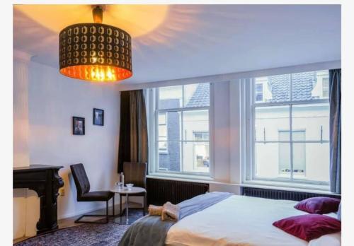 a bedroom with a bed and a large window at Zala's B&B in Utrecht