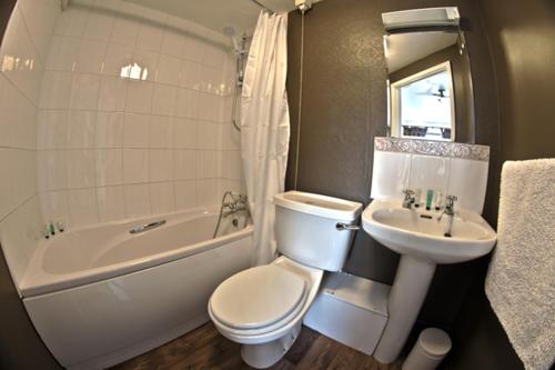 a bathroom with a toilet and a sink and a bath tub at The Chequers Inn in Darlington
