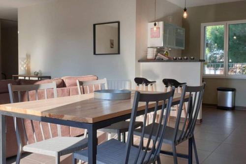 a dining table and chairs in a living room at La QUINTA in Vaux-sur-Mer