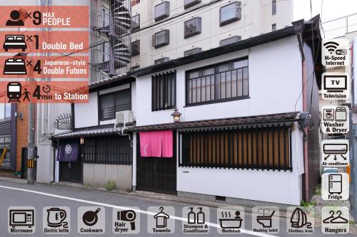 a white building on a street with street signs at Oyado Sanjo Machiya in Kyoto