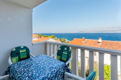 Un balcón con una cama y sillas y el océano en Villa Stella, en Splitska