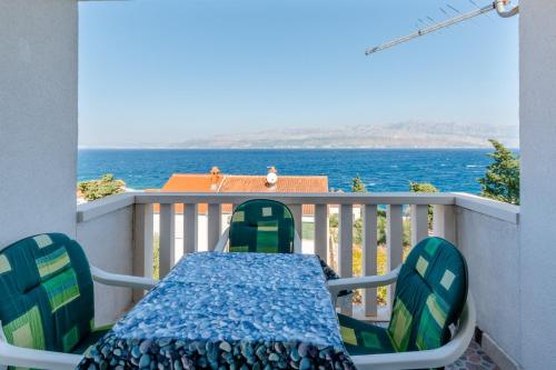 una mesa y sillas en un balcón con vistas al océano en Villa Stella, en Splitska