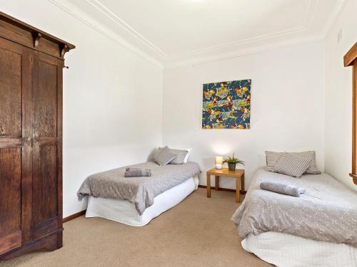 a bedroom with two beds and a painting on the wall at Time To Unwind in Culburra Beach