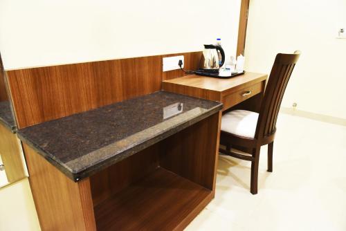 a desk in a room with a chair next to a table at Hotel Amritsar International 2 min walk from Amritsar Bus Stand in Amritsar