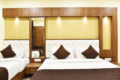 1 Schlafzimmer mit 2 Betten und einem großen Spiegel in der Unterkunft Hotel Amritsar International in Amritsar