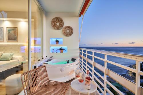 a room with a tub and a balcony with the ocean at SUNSET BEACH Charming apartment with jacuzzi in Torremolinos