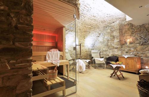 a room with a stone wall and a table and chairs at Hotel Herrnschloesschen in Rothenburg ob der Tauber