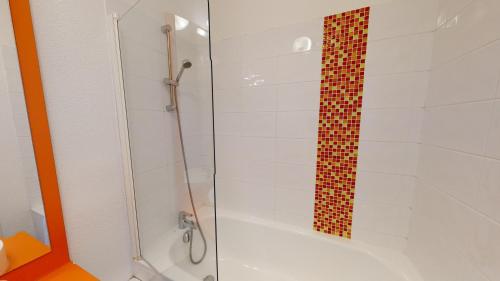 a bathroom with a shower with a glass door at Alezan Hôtel & Résidence in Toulouse