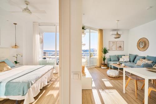 biała sypialnia z łóżkiem i kanapą w obiekcie SUNSET BEACH Charming apartment with jacuzzi w mieście Torremolinos