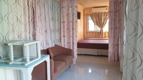 a room with a couch and a bed with a window at Baan Suan Chiva Saran in Nong Bua Lamphu