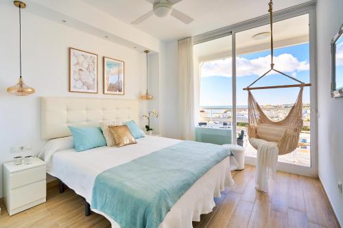 a bedroom with a swinging bed and a large window at SUNSET BEACH Charming apartment with jacuzzi in Torremolinos