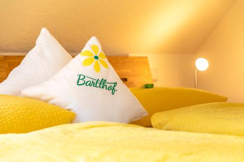 a pillow with a flower on it sitting on a bed at Bartlhof-Ferienwohnungen-Zimmer in Burglengenfeld