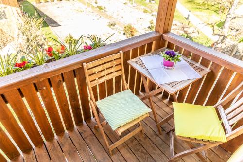 a wooden balcony with a table and two chairs at Bartlhof-Ferienwohnungen-Zimmer in Burglengenfeld