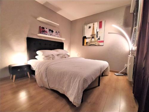 a bedroom with a bed with a white bedspread at Cocoon'Inn Blagnac in Blagnac