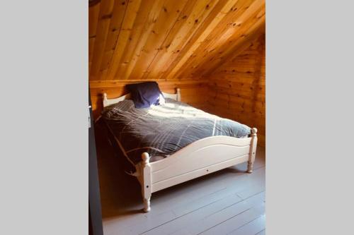 Cama en habitación con techo de madera en Chalet Bois Laruns en Laruns