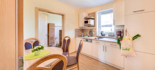 a kitchen with a table and chairs in a room at Bartlhof-Ferienwohnungen-Zimmer in Burglengenfeld
