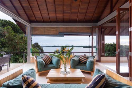 a porch with couches and a table and a view of the water at Sea Heart House on Koggala Lake in Koggala