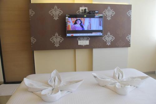 Zimmer mit zwei weißen Schüsseln auf einem Tisch und einem TV in der Unterkunft Hotel SaiPrasad Executive Solapur in Solapur