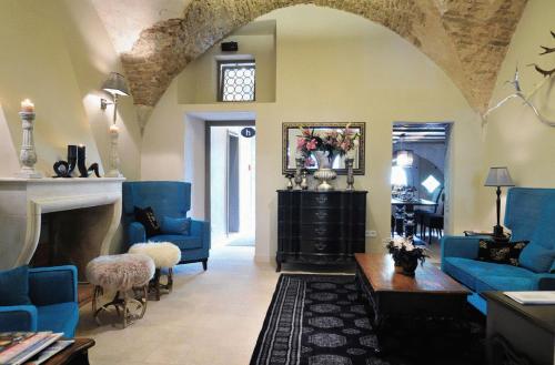 a living room with blue furniture and a fireplace at Hotel Herrnschloesschen in Rothenburg ob der Tauber