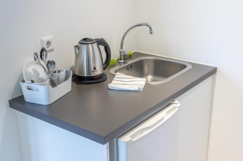 a kitchen counter with a sink and utensils at bedpark Stellingen in Hamburg