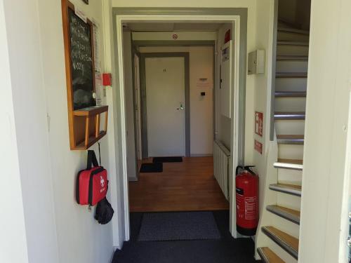 a hallway with a room with a fire extinguisher and a staircase at Brukshotellet Skinnsberg in Skinnskatteberg
