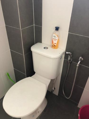 a bathroom with a toilet with a bottle of soap on it at Hasnifana Homestay Seri Iskandar in Seri Iskandar