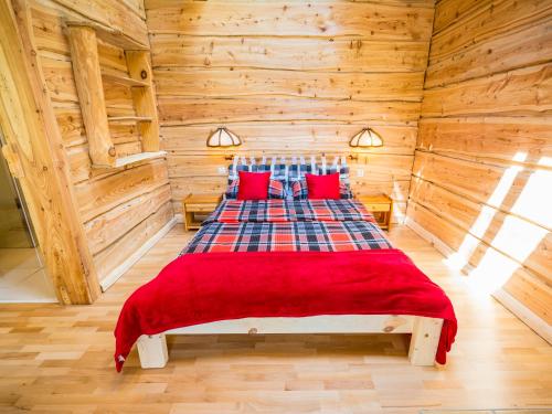 sypialnia z łóżkiem w drewnianym domku w obiekcie Witalna Osada Helonowo w mieście Ropienka