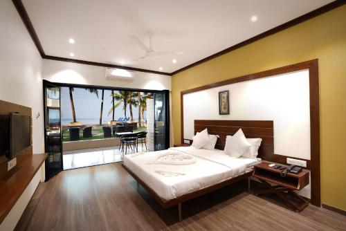 a bedroom with a large bed and a television at The Windmill Resorts in Malvan