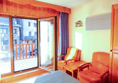 a room with a bed and a chair and a balcony at Kione Calgary in Pas de la Casa